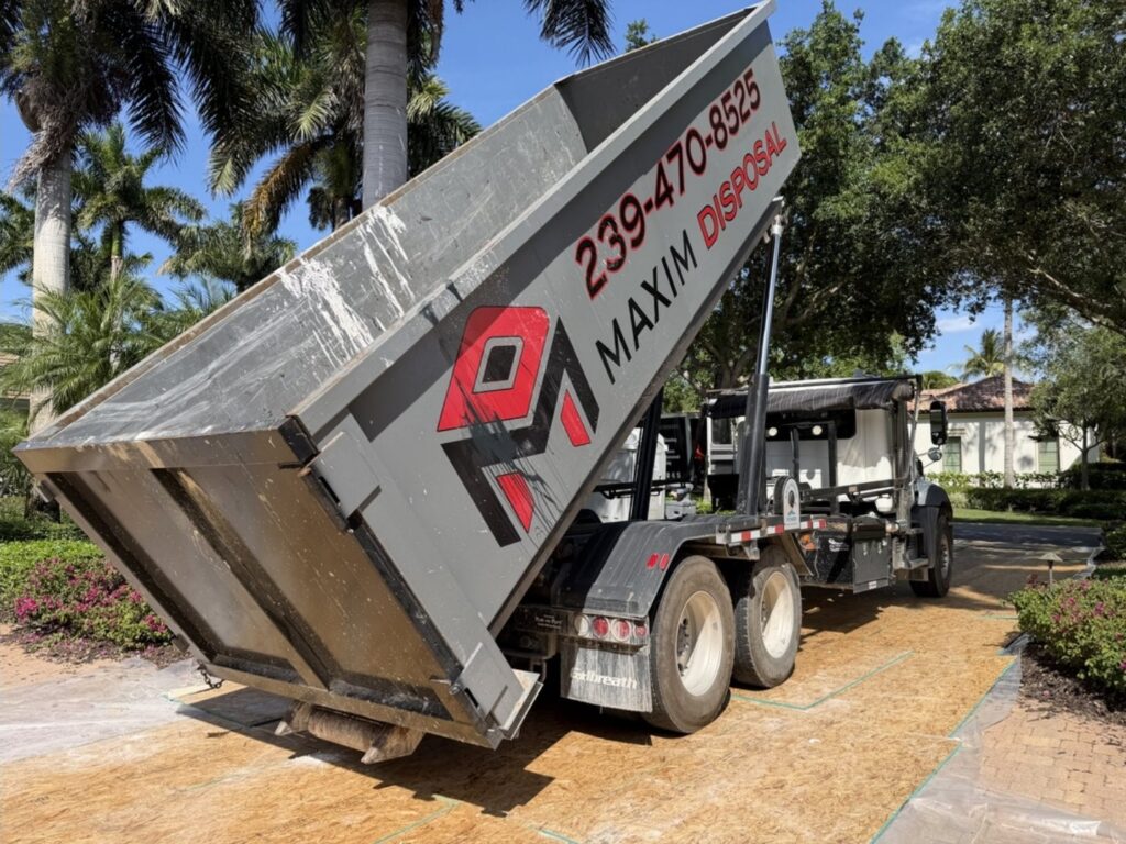 Maxim Disposal roll-off container being delivered onto plywood driveway protection